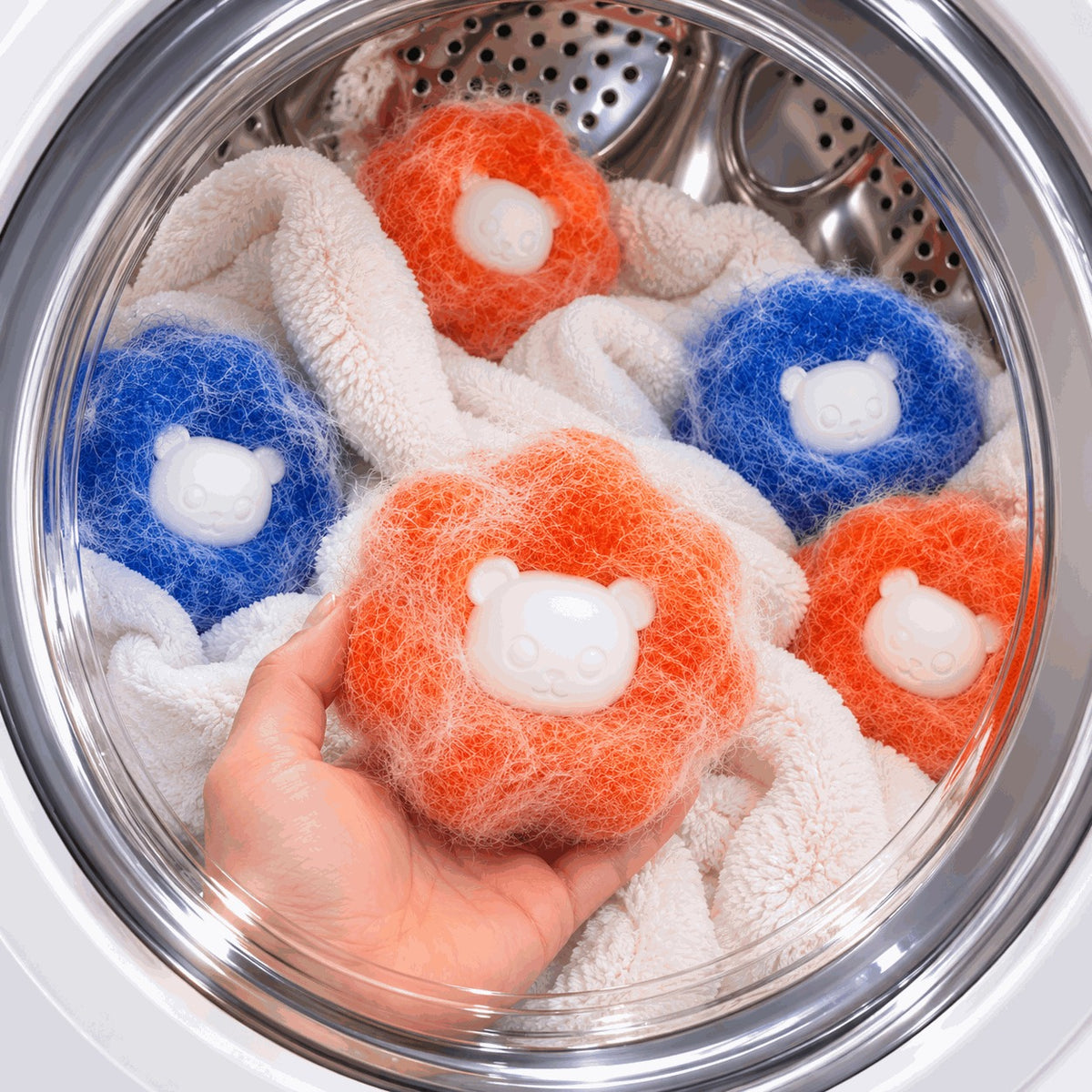 Furloop balls covered in pet hair inside a washing machine drum